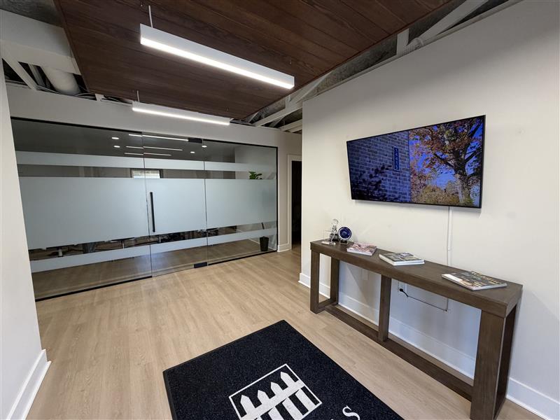 Entry vestibule at 401 Commerce Drive looking down the corridor, with a wall-mounted display and wood-look flooring