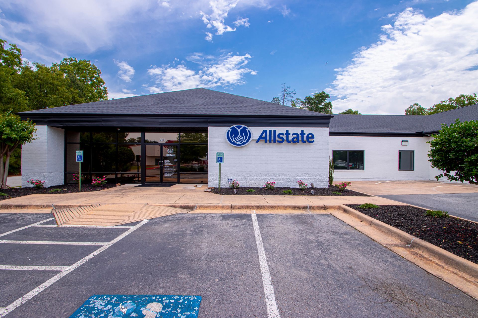 Allstate insurance office exterior with parking lot and blue sky