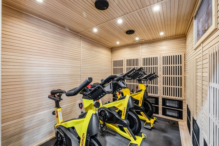 Indoor cycling studio with yellow exercise bikes in a wood-paneled room
