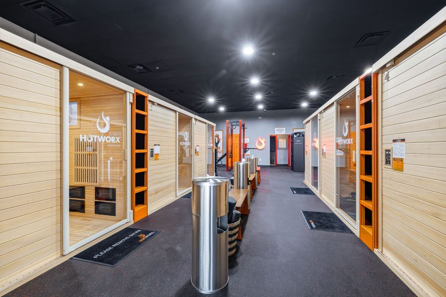Modern self-storage hallway with beige unit doors, wood trim, and black ceiling lights