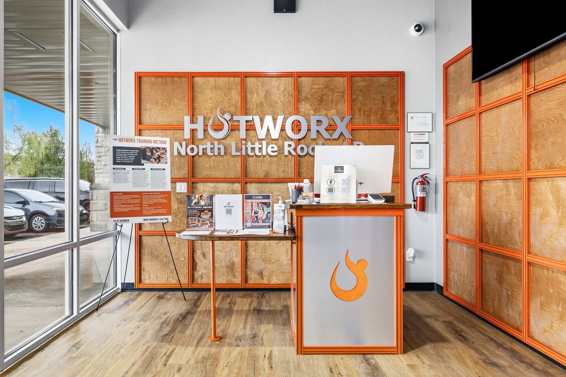 HOTWORX North Little Rock reception desk with orange branding and a wall display inside a bright lobby